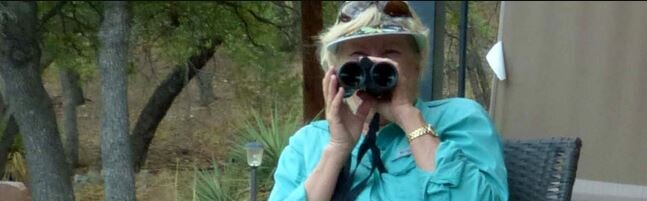 A woman with binoculars bird watching