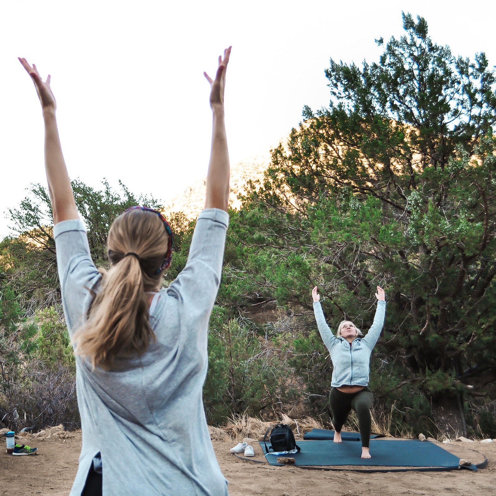 A woman teaching a yoga class in a natural, outdoor setting
