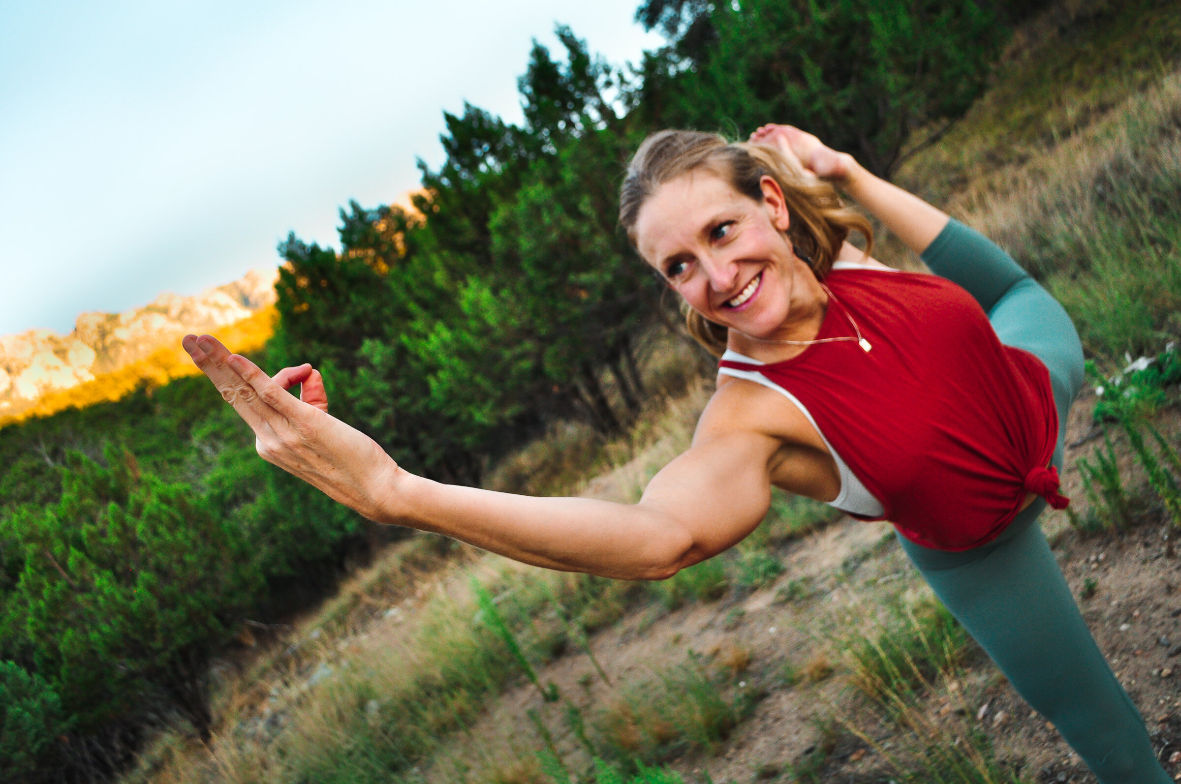 A woman doing a yoga pose in a natural setting